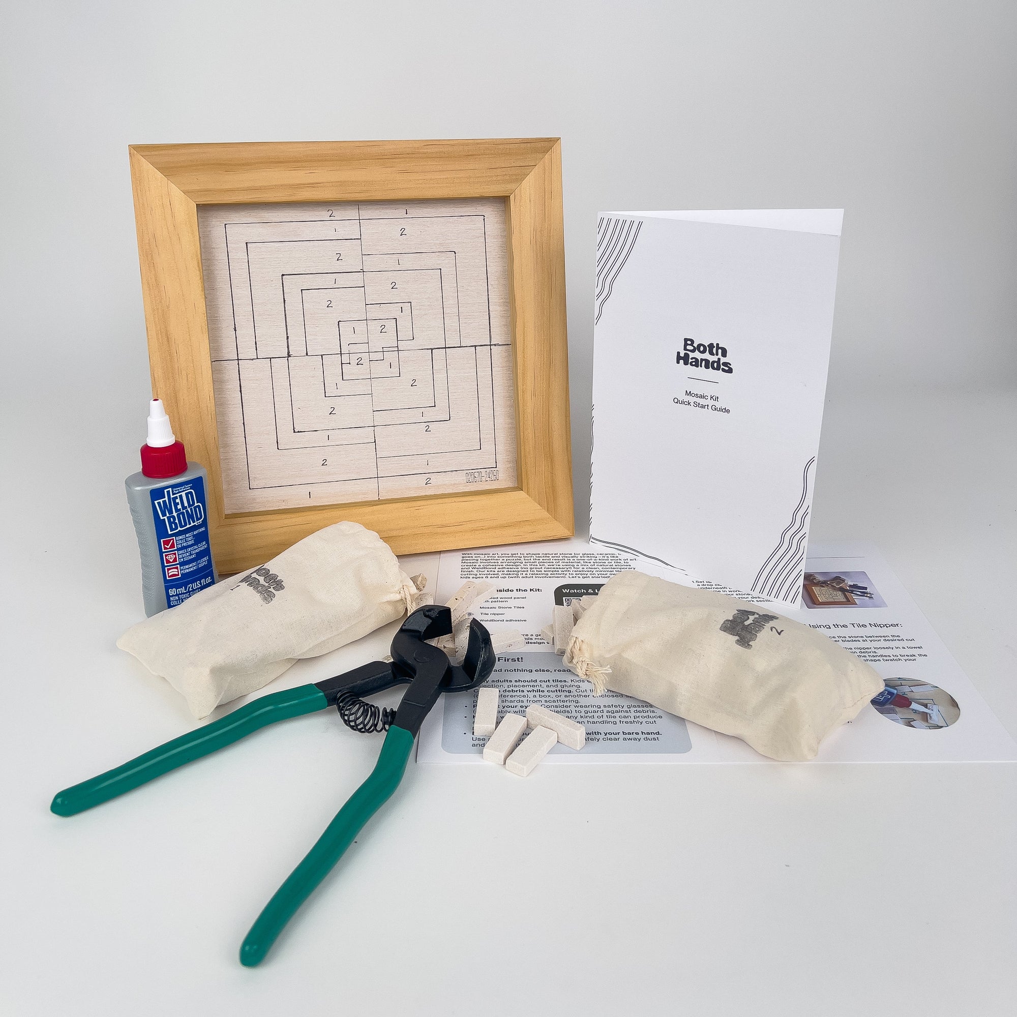 Crafting kit with wooden frame, pliers, glue, and instructions on a white background
